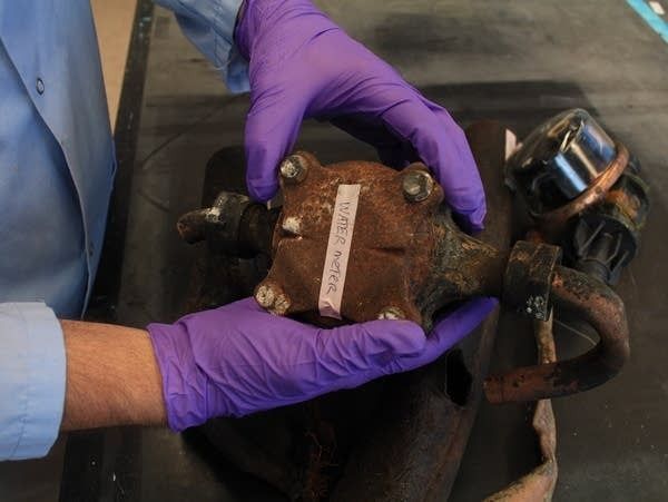 Whelton holds a piece of fire-damaged water infrastructure in his lab. 