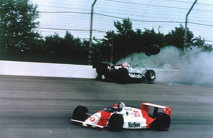 FILE - In this May 28, 1989, file photo, Emerson Fittipaldi, bottom, takes the lead with less than two laps remaining as Al Unser Jr. crashes into the wall during the 73rd running of the Indianapolis 500 auto race at Indianapolis Motor Speedway.