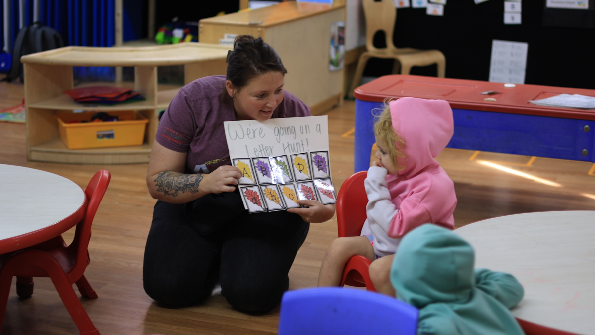 Teacher Halie Stinemetz works with students at The Growing Garden Learning Center on Wednesday, Oct. 1, 2025. Two of her children attend Growing Garden. (Zach Bundy/WFYI)