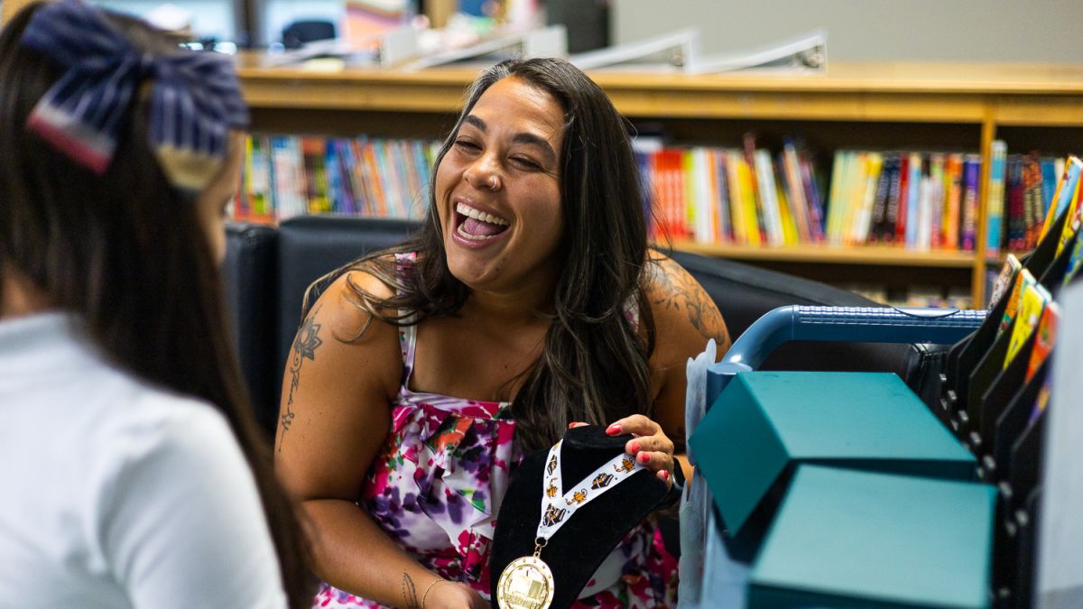 Enlace Academy school leader Stephanie Campos shows a students books and other items on a reading cart on Wednesday, Aug. 20, 2025. 