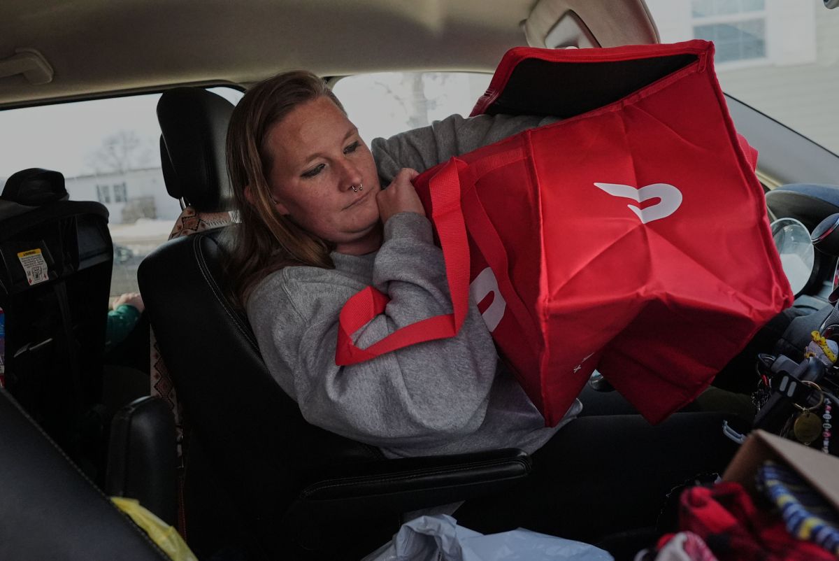 Dianna Tompkins checks on her a new DoorDash bag in her car in Demotte, Wednesday Dec. 17, 2025.