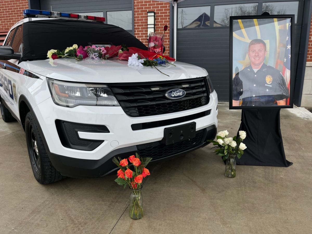Community members added to a memorial at Officer Elliott’s cruiser parked outside the Beech Grove Police Department.
