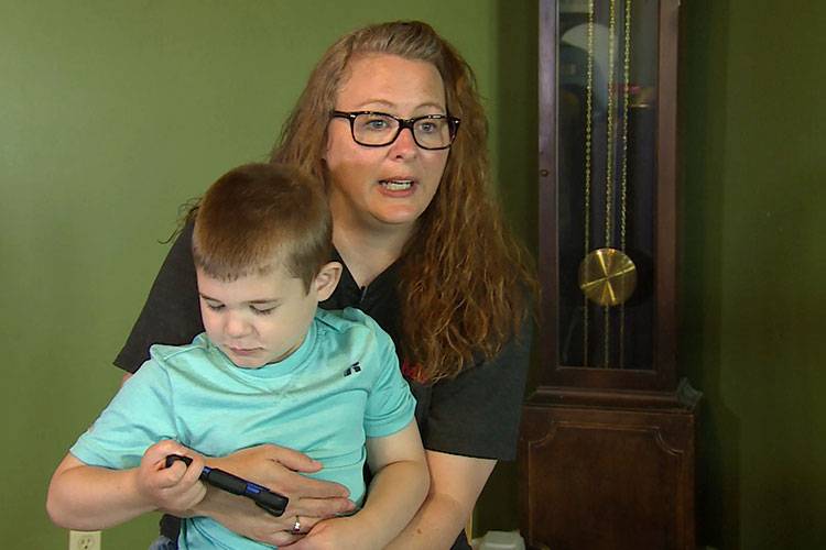 Miriah Mershon holds her 7 year-old son Jameson. Mershon says her family has done a lot to help prevent Jameson's seizures, including cutting down trees in her front yard. 