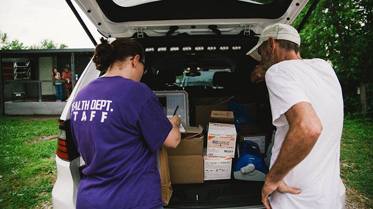 Brittany Combs is seen delivering clean needles and other supplies to a member of Scott County's needle exchange program.