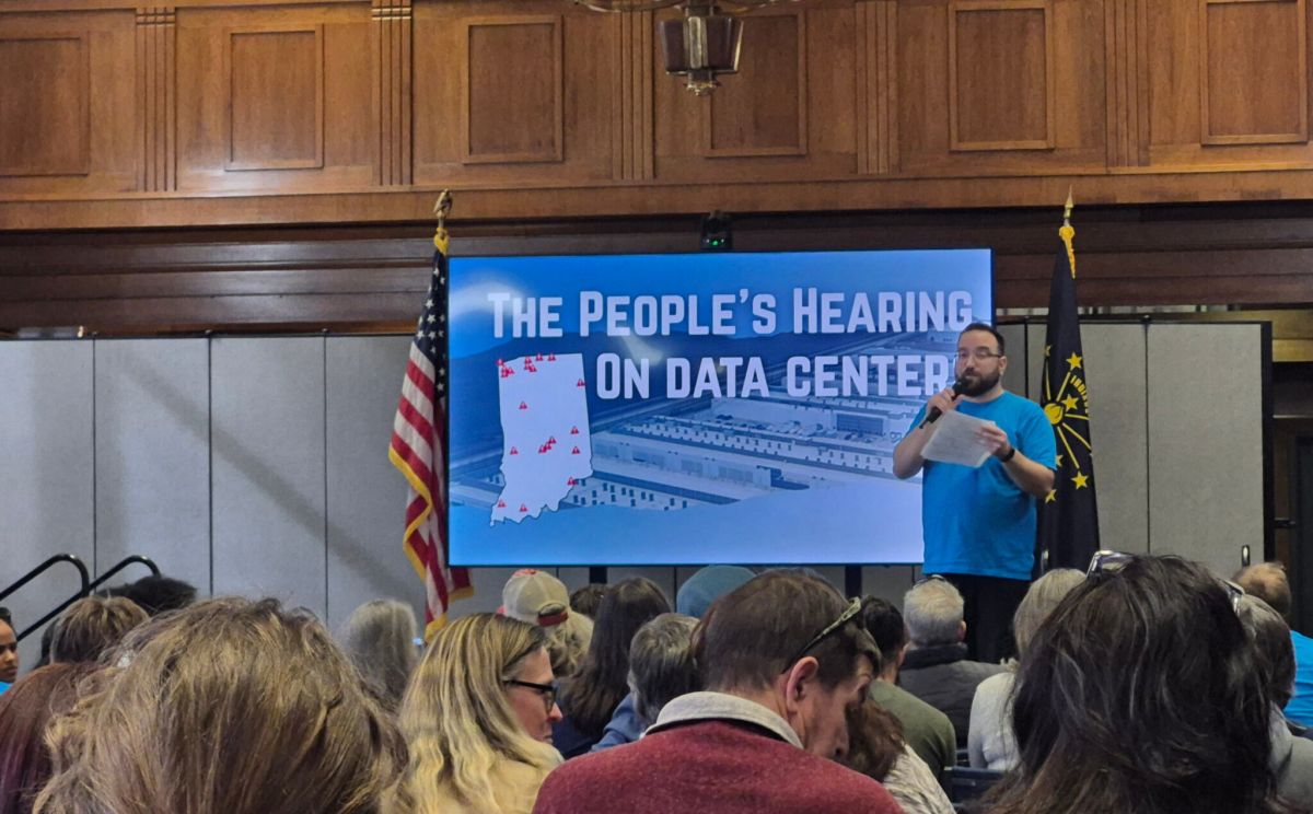 Will Stauffer, an organizer for the community group Hoosier Action, introduces speakers at The People’s Hearing on Data Centers, on Feb. 24, 2026 at the Indiana State Library. The event gathered elected officials, experts, and community leaders to discuss the growing public concern about hyperscale data centers in Indiana. (Tracey Compton/Indy Public Editor)