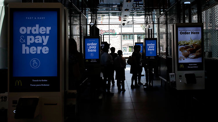 FILE- This Aug. 8, 2018, file photo shows electronic menus at McDonald's flagship restaurant in Chicago. Robots aren’t replacing everyone, but a quarter of U.S. jobs will be severely disrupted as artificial intelligence accelerates the automation of today’s work, according to a new Brookings Institution report.  - AP Photo/Nam Y. Huh, File