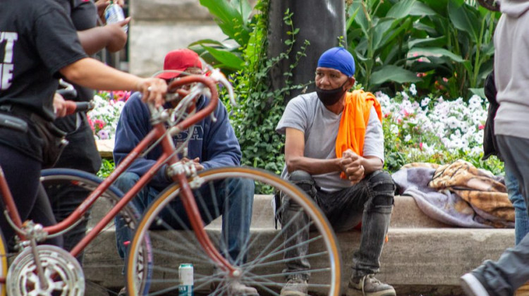 People who are homeless sit on the ledge surrounding Monument Circle in downtown Indianapolis. The COVID-19 pandemic has highlighted how racial minorities and lower-income communities – in both the U.S. and across the globe – get hit the hardest during major health crises. - (Tyler Fenwick/Indianapolis Recorder)