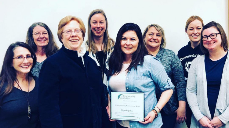 Sistering CU co-founder Erin Murphy (center) holds a certificate from the Community Foundation of East Central Illinois, which awarded the organization a grant to purchase Baby Boxes for new mothers. - Sistering CU via Facebook