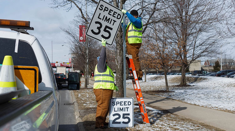 Indianapolis Public Works employees change the speed limit sign along Michigan Street.  - Liz Kaye/Indiana University