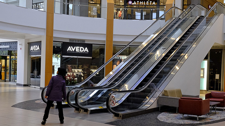 A visitor looks down an empty hallway at The Fashion Mall at Keystone, Wednesday, March 18, 2020, in Indianapolis. Simon Property Group, the largest owner of shopping malls in the nation, is closing all of its malls and retail properties because of the coronavirus outbreak. - AP Photo/Darron Cummings