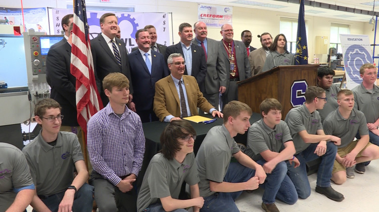 Gov. Eric Holcomb and legislators pose with students at Seymour High School after signing a career and technical education bill into law. - Zachary Herndon/WTIU