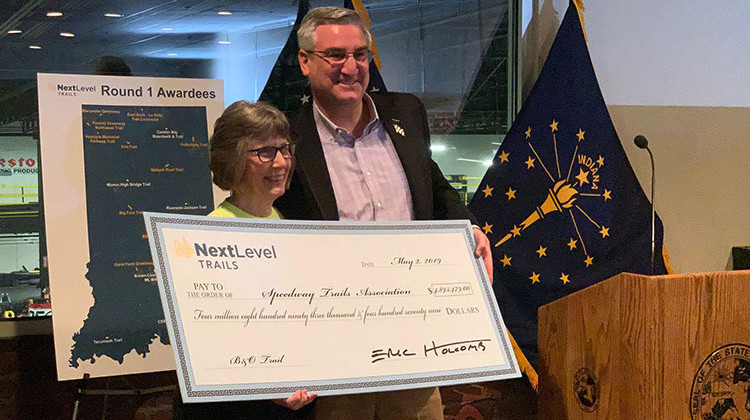 Gov. Eric Holcomb poses with the head of the Speedway Trails Association, which received the single largest award from the first round of the Next Level Trails program. - Brandon Smith/IPB News