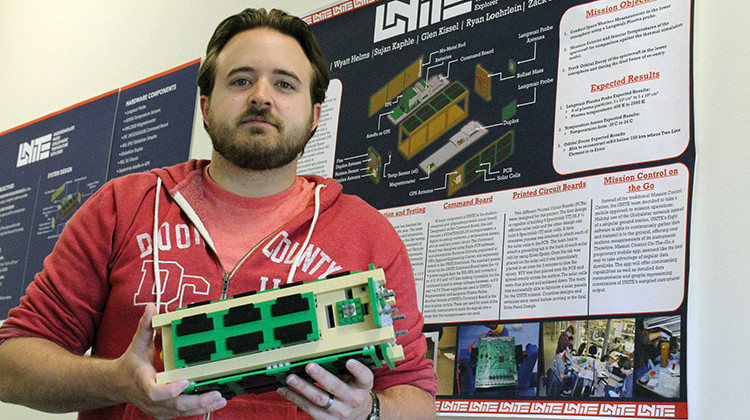 USI senior Nathan Kalsch poses with a Lego model of UNITE CubeSat. - Isaiah Seibert/WNIN
