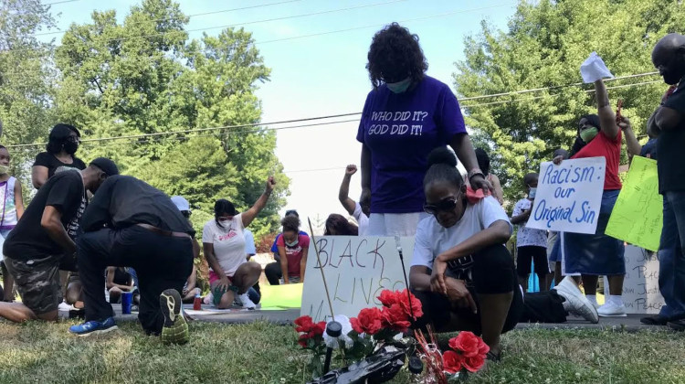 Tara Williams kneels over the site where her son, Malcolm Williams, was shot and killed by an Indiana State Police trooper at a protest in Jeffersonville, Indiana.  - John Boyle / LPM