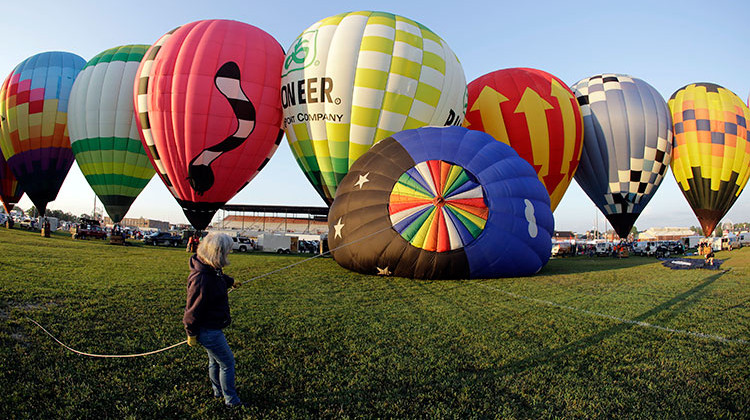 Tommi Derado holds onto a balloon before the hot air balloon race at the Indiana State Fair, Friday, Aug. 3, 2018, in Indianapolis. - AP Photo/Darron Cummings