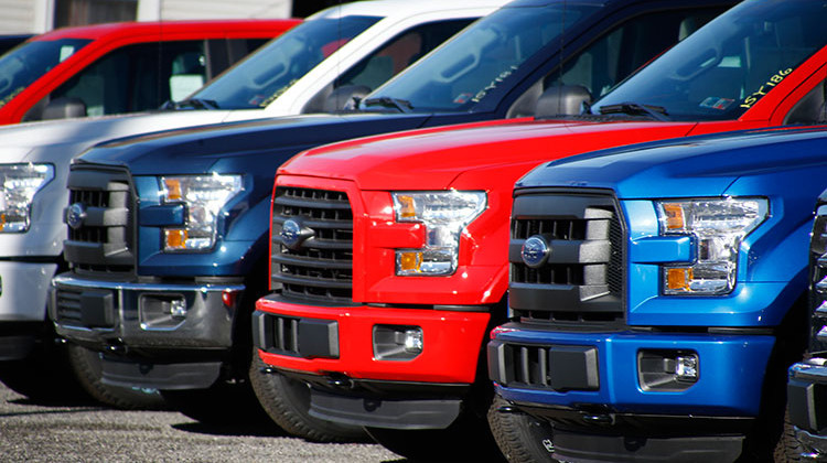FILE- In this Nov. 19, 2015, file photo a row of 2015 Ford F-150 pickup trucks are parked on the sales lot at Butler County Ford in Butler, Pa. Under pressure from U.S. safety regulators, Ford is recalling about 2 million F-150 pickups in North America because the seat belts can cause fires. The recall covers certain trucks from the 2015 through 2018 model years.  - AP Photo/Keith Srakocic, File