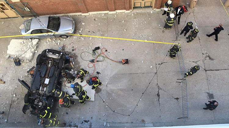Indianapolis firefighters work on a vehicle that plunged off of the fourth floor of a downtown parking garage Wednesday morning.. - Provided by Indianapolis Fire Department