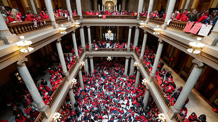 FILE - In this Nov. 19, 2019, file photo thousands of Indiana teachers wearing red hold rally at the Statehouse in Indianapolis. The Statehouse rally put complaints about their treatment squarely in front of Indiana lawmakers as this year’s legislative session was about to start. But those loud chants for improved school funding didn’t result in any additional money.  - AP Photo/Michael Conroy, File