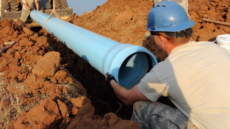 Airmen at Altus Air Force Base in Oklahoma install a water pipe behind a tanker fuel yard, 2012 - (U.S. Air Force)
