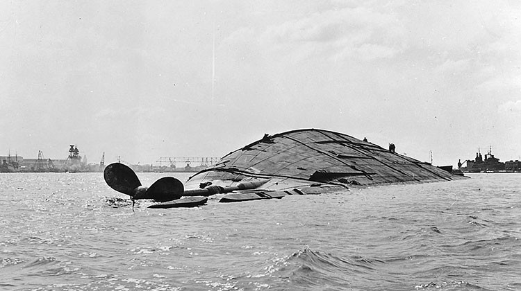 The U.S. Navy battleship USS Oklahoma, shown here following the Dec. 7, 1941 attack on Pearl Harbor, suffered multiple torpedo hits and capsized. Four hundred twenty-nine crewmen aboard the ship died. - National Archives/U.S. Navy