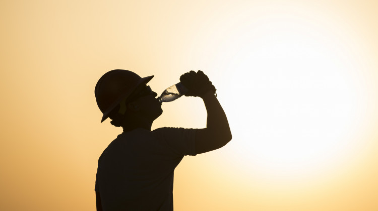 A U.S. airman drinks water while working on a construction site in extreme heat in Southwest Asia, 2017.  - U.S. Air Force/Damon Kasberg