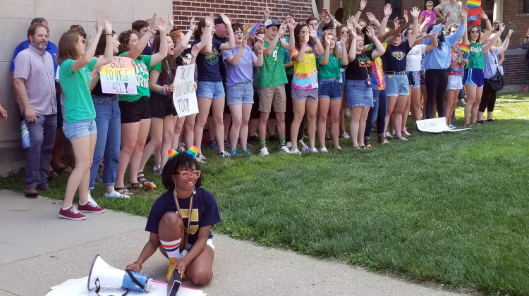 Student organizer Brooklynn Thorpe uses a megaphone to amplify music as fellow students lead school chants and cheers outside of the Archdiocese of Indianapolis during a protest Thursday, June 27, 2019. - Jeanie Lindsay/IPB News