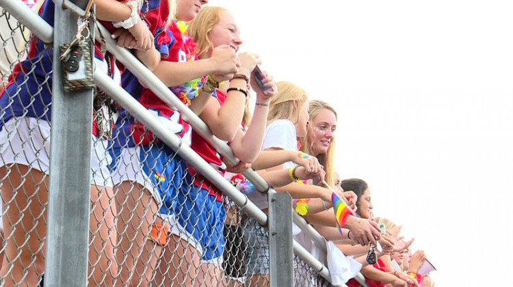 Roncalli students wave rainbow flags during their first football game of the season in support of Shelly Fitzgerald, a guidance counselor whose job has been threatened because of her marriage to a woman.  - Lauren Chapman/IPB News
