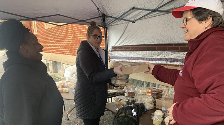 St. Margaret's House Executive Director Kathy Schneider helps serve food to South Bend resident Donna King and other women. - Anncaroline Caruso/WVPE