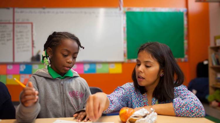 Maria Rocha helps a student with the morning warm-up in her third-grade science class. - Katie Hayes Luke for NPR