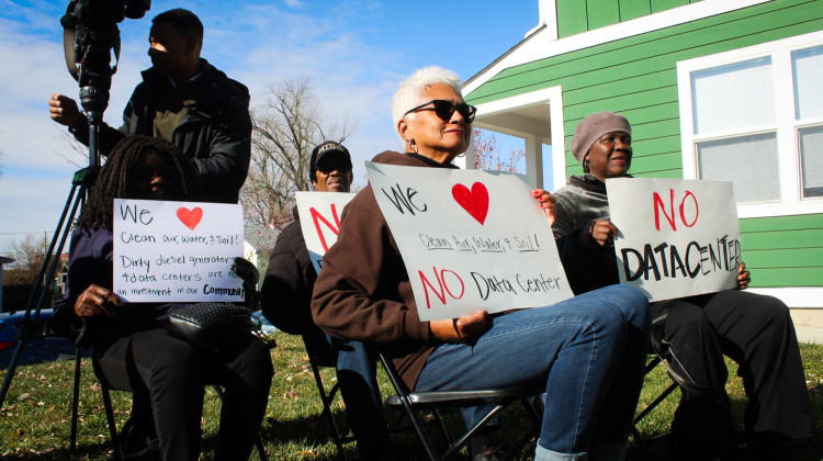 Residents display signs at a press conference in Indianapolis’ Martindale-Brightwood neighborhood on Monday, Nov. 17, 2025. Organizers said the proposed Metrobloks data center would threaten local environmental cleanup efforts and fail to serve the community’s needs. - Farrah Anderson, WFYI
