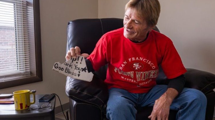 Resident Dean Cooksey, now living at the renovated facility on the city’s near north side, proudly displays a phone stand he crafted from the remnants of a sign he once used while seeking help at Southside intersections before joining the program.  - Doug McSchooler / Mirror Indy