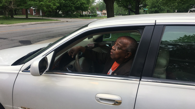 Indianapolis City-County Councilor William Oliver demonstrated reaching for a cell phone and registration in his car during a press conference outside his home. - Carter Barrett/WFYI