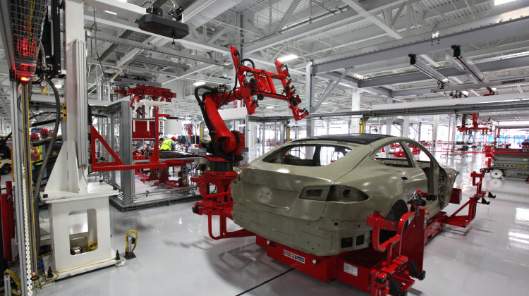 A machine installs a glass sun roof on an electric car at a Tesla factory. - Steve Jurvetson
/
Flickr