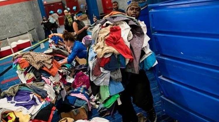 Volunteers sort through donated clothing at a shelter in the George R. Brown Convention Center during the aftermath of Hurricane Harvey on August 28 in Houston, Texas. - Brendan Smialowsk/AFP/Getty Images