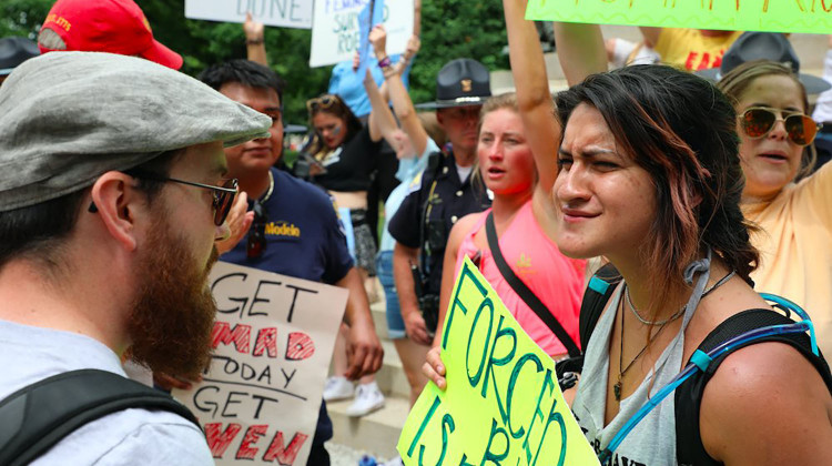 Thousands of people came to the Indiana Statehouse on Saturday, June 25, 2022, to advocate for abortion rights. A much smaller number also gathered to support the U.S. Supreme Court's decision to end the constitutional protections for abortion. Two 28-year-olds, Melissa Eleonora Mena-Schneller, right, and Austin, left, debate whether a woman should have the choice to end a pregnancy. - Eric Weddle/WFYI