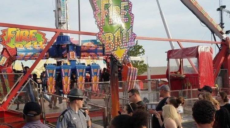 People watch as authorities respond after part of the Fire Ball ride broke off while in motion Wednesday night at the Ohio State Fair in Columbus, Ohio. One person was killed, and three were critically injured. - Justin Eckard/AP