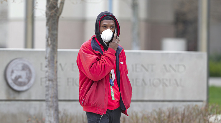 A man walks through the deserted Indiana State office complex in Indianapolis, Tuesday, March 24, 2020. - AP Photo/Michael Conroy