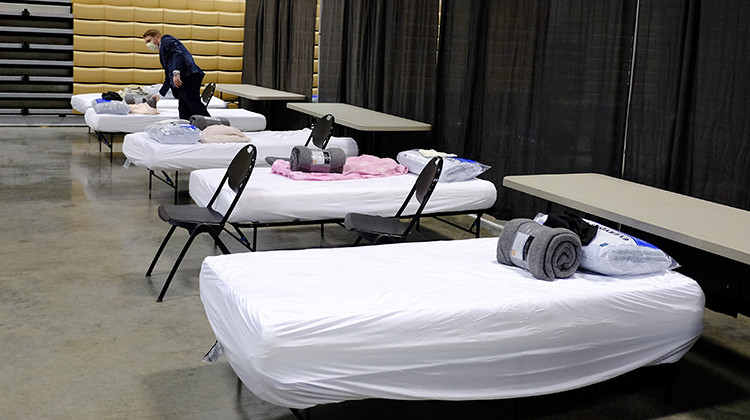 Brett Peppin, director of environmental health with Boone County Health Department, looks at the items on a bed in a building at the Boone County 4-H Fairgrounds, Monday, April 6, 2020, in Lebanon, Ind. The building was prepared to handle 75 COVID-19 patients. The new coronavirus causes mild or moderate symptoms for most people, but for some, especially older adults and people with existing health problems, it can cause more severe illness or death.  - AP Photo/Darron Cummings