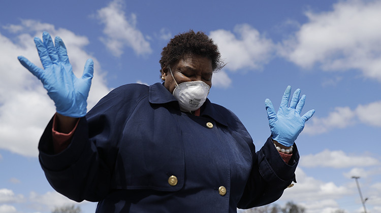 Deborah Harrison prays during a drive-thru Holy Communion on Good Friday at Grace Apostolic Church, Friday, April 10, 2020, in Indianapolis. The new coronavirus causes mild or moderate symptoms for most people, but for some, especially older adults and people with existing health problems, it can cause more severe illness or death. - AP Photo/Darron Cummings