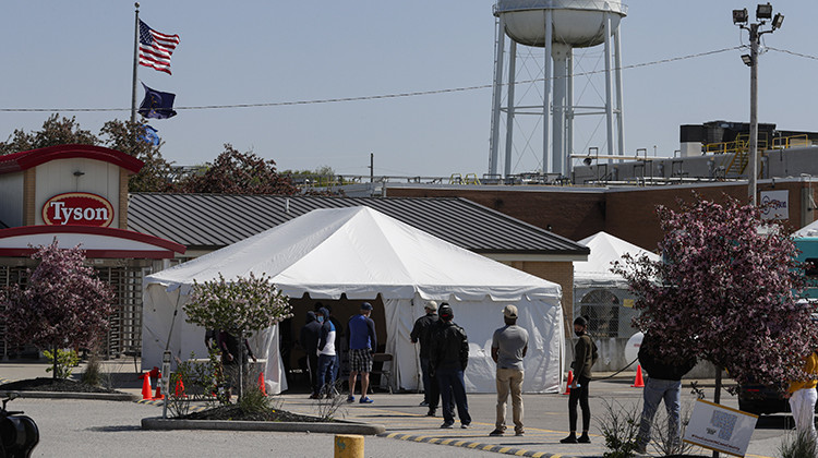 Workers wait in line to enter the Tyson Foods pork processing plant in Logansport, Ind., Thursday, May 7, 2020. The plant was expected to Thursday after closing on April 25 after nearly 900 employees tested positive for the coronavirus. Workers won't be able to return to work until they get tested. - AP Photo/Michael Conroy