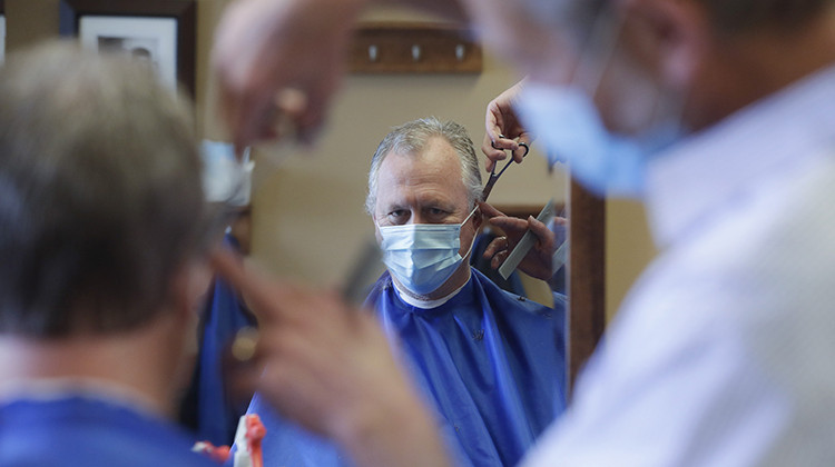 Geoff Brown gets a haircut from Mike Nell at the Boone Village Barber Shop, Monday, May 11, 2020, in Zionsville, Ind. Barber shops have been closed to prevent the spread of the coronavirus and were allowed to open Monday by appointment and following social distancing guidelines.  - AP Photo/Darron Cummings