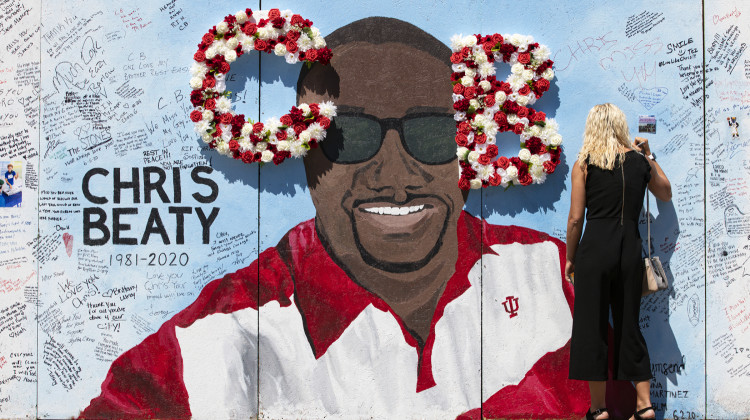 In this June 12, 2020 file photo, a mourner signs a tribute wall during a memorial service for former Indiana University football player Chris Beaty in Indianapolis. Three people have been convicted in the fatal shooting of a former Indiana University football player who was gunned down during unrest in Indianapolis following the death of George Floyd. - AP Photo/Michael Conroy