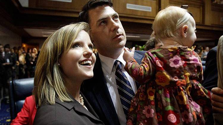 Indiana Republican Sen. Jim Banks, holds his daughter, Lillian, with wife Amanda Banks after taking the oath of office during organization day at the Statehouse in Indianapolis, Tuesday, Nov. 16, 2010. - AP Photo/Darron Cummings