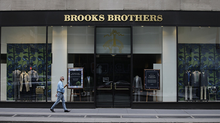 FILE - Pedestrians wearing protective masks walk past a Brooks Brothers location in a July 8, 2020 file photo, in New York.  - AP Photo/Frank Franklin II, File