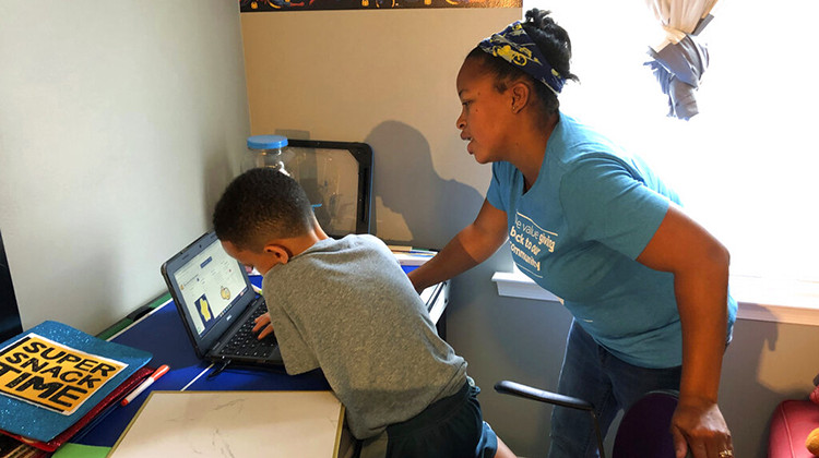 Tiffany Shelton helps her 7-year-old son, P.J. Shelton, a second-grader, during an online class at their home in Norristown, Pa., on Thursday, Sept. 3, 2020. Norristown Area School District plans to offer online-only instruction through at least January 2021. - AP Photo/Michael Rubinkam