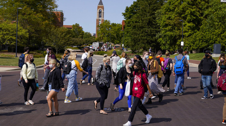 FILE - In this Sept. 10, 2020, file photo, masked students cross an intersection on the campus of Ball State University in Muncie, Ind. President Donald Trump’s startling COVID-19 diagnosis serves as a cruel reminder of the pervasive spread of the coronavirus in the United States and shows how tenuous of a grip the nation has on the crisis, health experts said.  - AP Photo/Michael Conroy, File