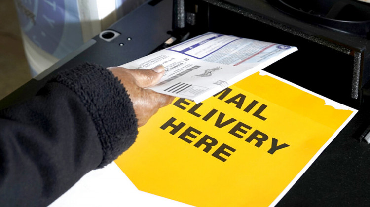 A Cook County, Ill., resident drops off her mail-in ballot Tuesday, Oct. 13, 2020, at a county courthouse in Maywood, Ill.  - AP Photo/Charles Rex Arbogast