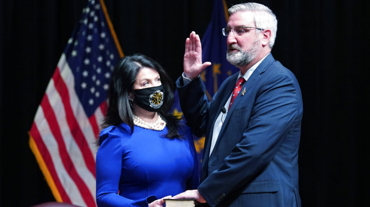 Eric Holcomb is sworn in as Indiana's governor by Chief Justice Loretta H. Rush on a bible held by his wife, Janet, during an inaugural ceremony at the Indiana State Museum, Monday, Jan. 11, 2021, in Indianapolis.  - AP Photo/Darron Cummings