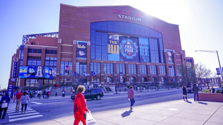 FILE - Fans walk outside Lucas Oil Stadium in Indianapolis before a college basketball game during the Final Four round of the NCAA tournament, in this Saturday, April 3, 2021, file photo. - AP Photo/AJ Mast, File