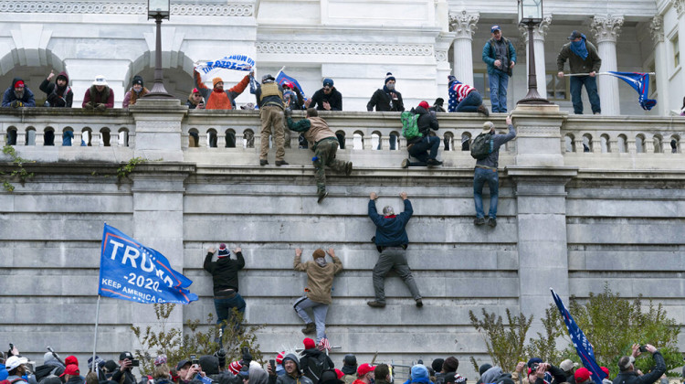 FILE - In this Jan. 6, 2021 file photo, violent insurrectionists loyal to President Donald Trump scale the west wall of the the U.S. Capitol in Washington. In the nearly nine months since Jan. 6, federal agents have managed to track down and arrest more than 600 people across the U.S. believed to have joined in the riot at the Capitol. Getting those cases swiftly to trial is turning out to be an even more difficult task.  - AP Photo/Jose Luis Magana, File